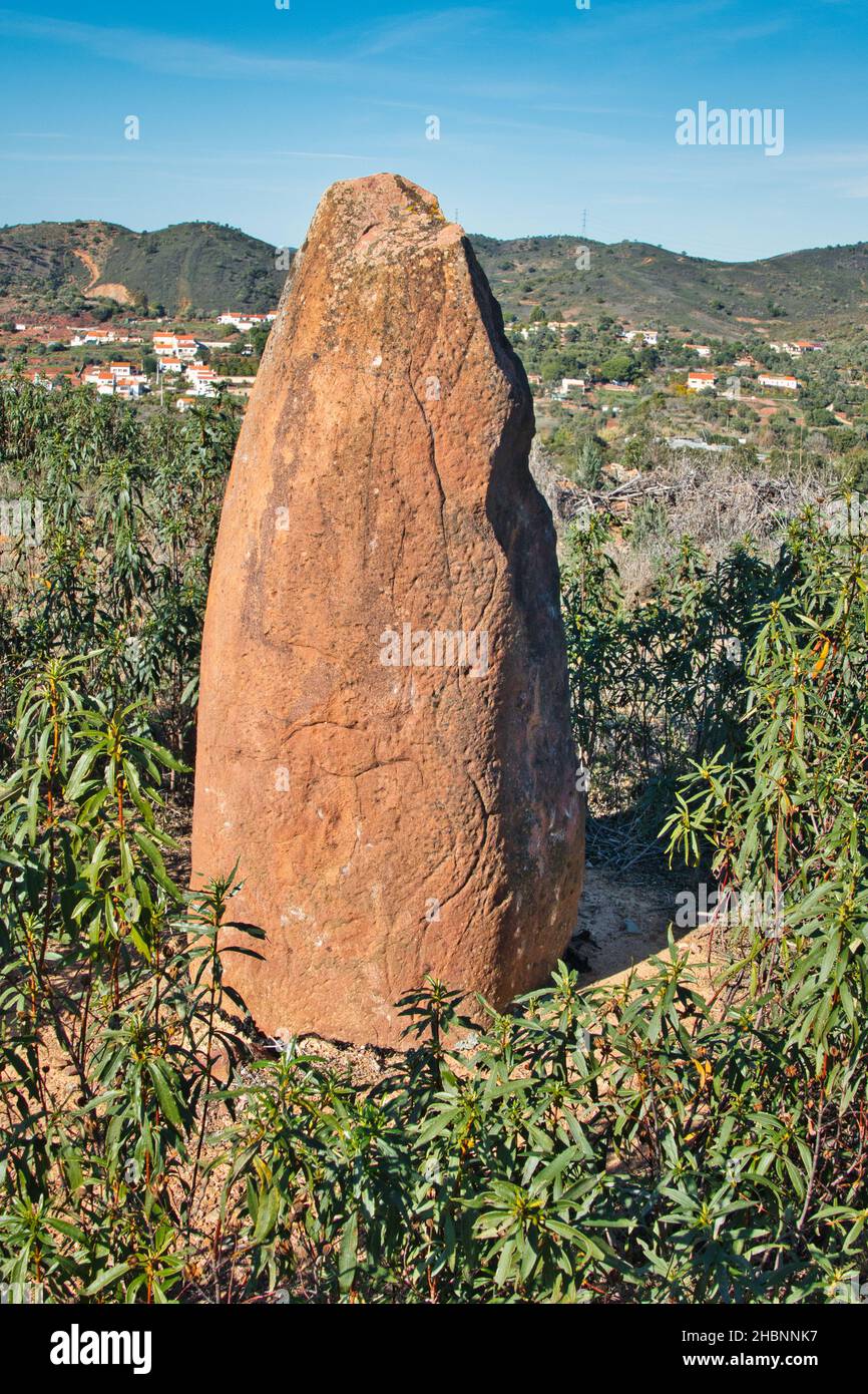 Sandstone menhir with mysterious inscribed symbols, dating from 6000-4500 BC, in the dry hills near Vale Fuzeiros, Algarve, Portugal. Stock Photo