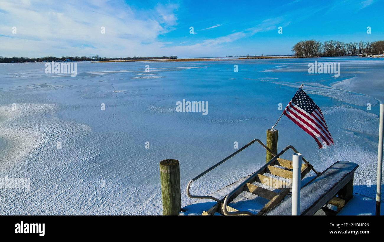 View from the dock of frozen lake Winneconne with American flag in the