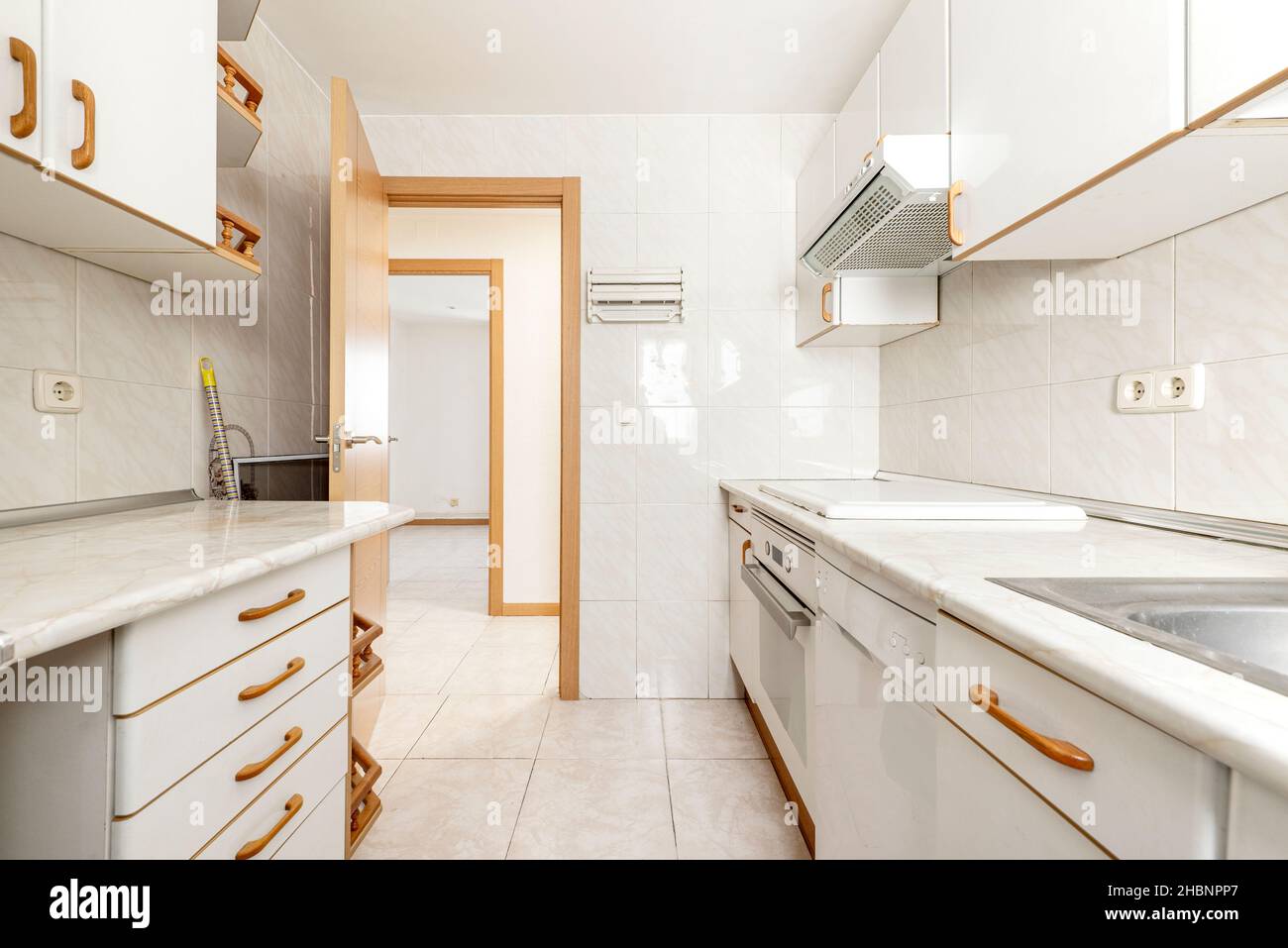 White fitted kitchen with cherry wood handles Stock Photo - Alamy