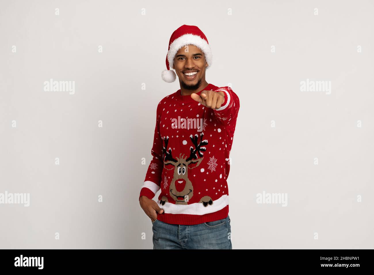Charismatic handsome black guy in Santa hat pointing at camera Stock Photo