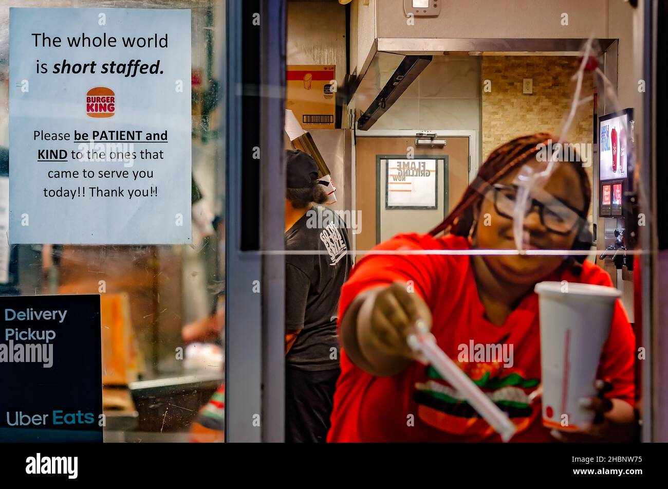 A sign at a Burger King drive-thru window encourages patrons to be patient and kind while the restaurant is short-staffed in Pascagoula, Mississippi. Stock Photo