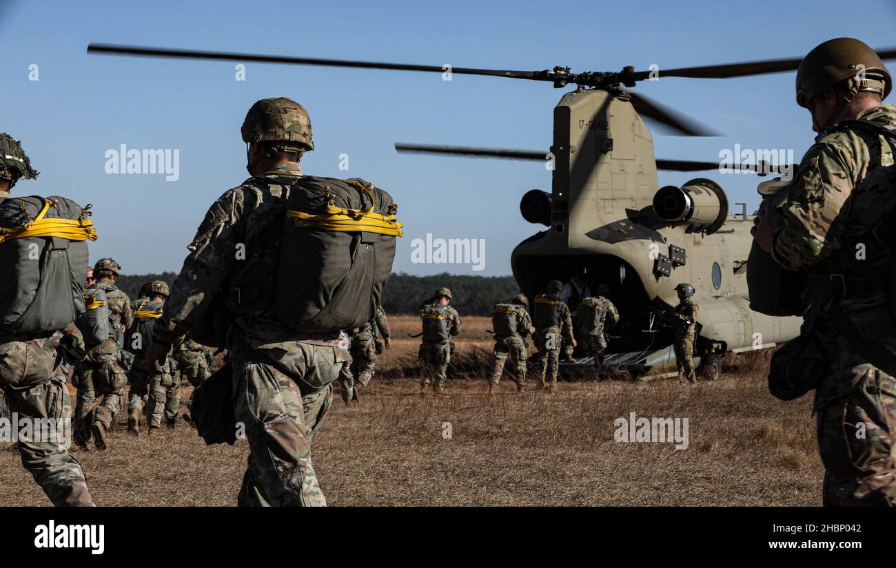 U.S. Army paratroopers board a CH-47 Chinook helicopter assigned to the 82nd Combat Aviation Brigade during an airborne exercise at Sicily drop zone, Fort Bragg, North Carolina, Dec. 15, 2021. The U.S. Army Reserve’s U.S. Army Civil Affairs and Psychological Operations Command (Airborne) and 824th Quartermaster Company partnered with Soldiers from the 82nd Airborne Division to conduct a non-tactical airborne operation with allied jump masters in order to maintain proficiency and earn foreign jump wings, Dec. 13-15, 2021. (U.S. Army photo by Spc. Cody Rich) Stock Photo