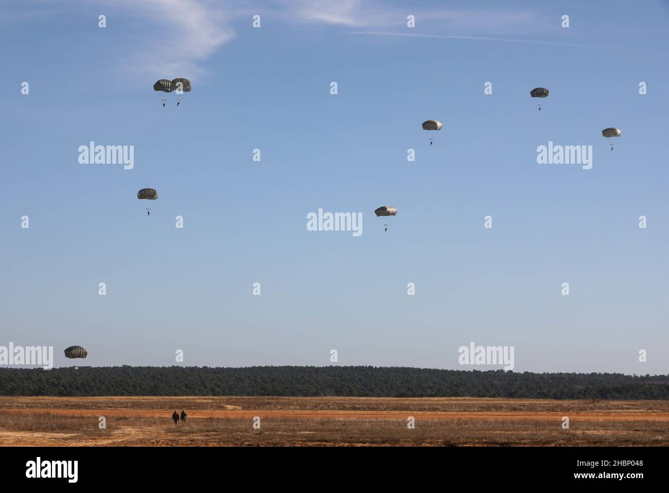 U.S. Army paratroopers assigned to the 82nd Airborne Division descend from a CH-47 Chinook (not in picture) during an airborne exercise at Sicily drop zone, Fort Bragg, North Carolina, Dec. 15, 2021. The U.S. Army Reserve’s U.S. Army Civil Affairs and Psychological Operations Command (Airborne) and 824th Quartermaster Company partnered with Soldiers from the 82nd Airborne Division to conduct a non-tactical airborne operation with allied jump master in order to maintain proficiency and earn foreign jump wings, Dec. 13-15, 2021. (U.S. Army photo by Spc. Cody Rich) Stock Photo
