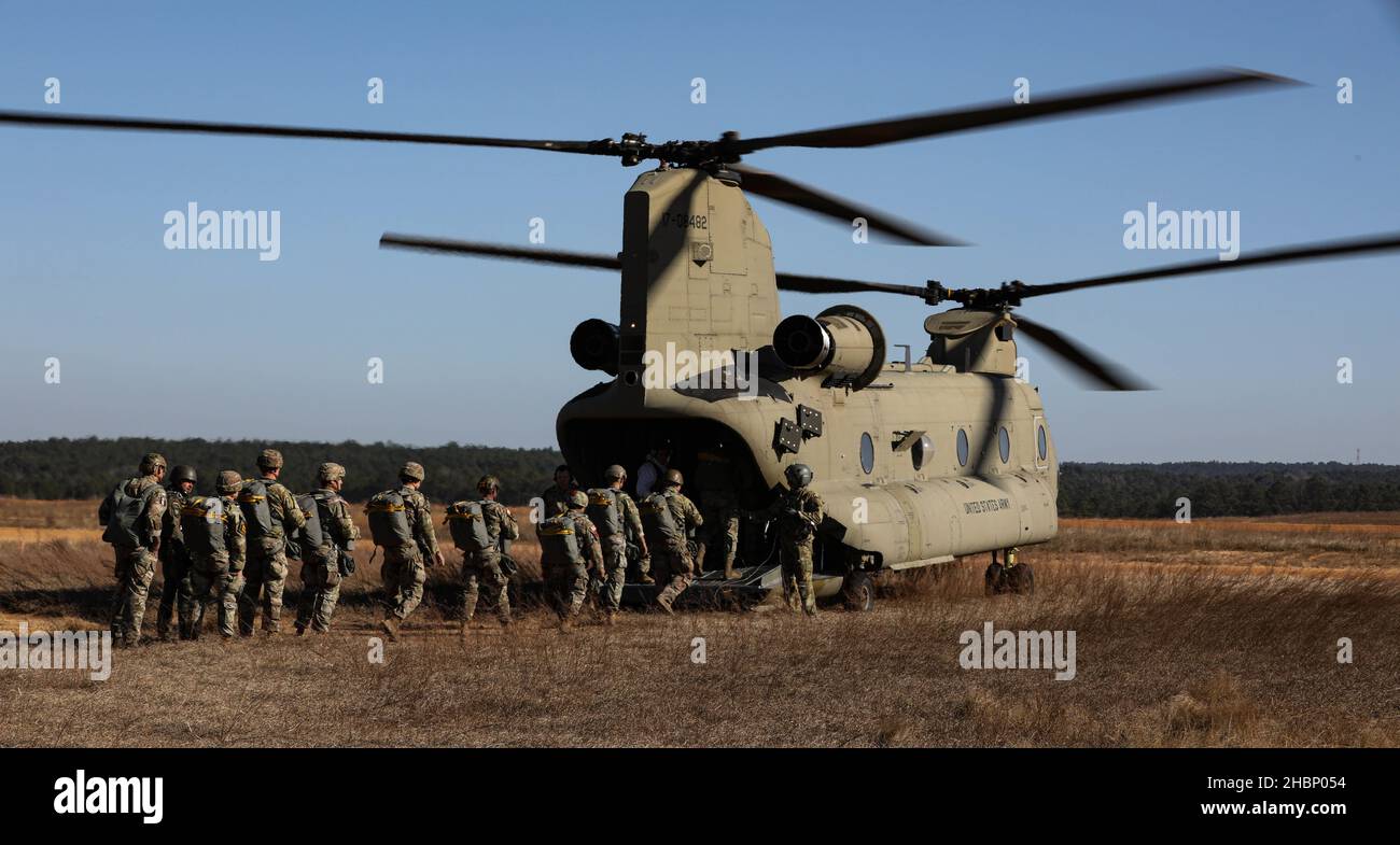 U.S. Army paratroopers board a CH-47 Chinook assigned to the 82nd Combat Aviation Brigade during an airborne exercise at Sicily drop zone, Fort Bragg, North Carolina, Dec. 15, 2021. The U.S. Army Reserve’s U.S. Army Civil Affairs and Psychological Operations Command (Airborne) and 824th Quartermaster Company partnered with Soldiers from the 82nd Airborne Division to conduct a non-tactical airborne operation with allied jump masters in order to maintain proficiency and earn foreign jump wings, Dec. 13-15, 2021. (U.S. Army photo by Spc. Cody Rich) Stock Photo
