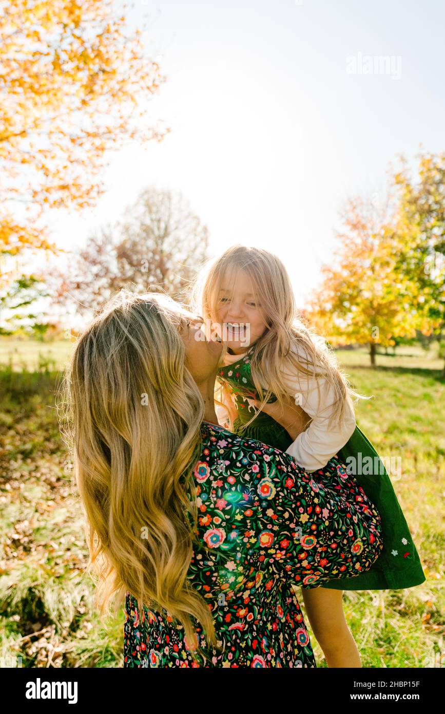 Closeup portrait of a mother lifting her laughing school age daughter Stock Photo