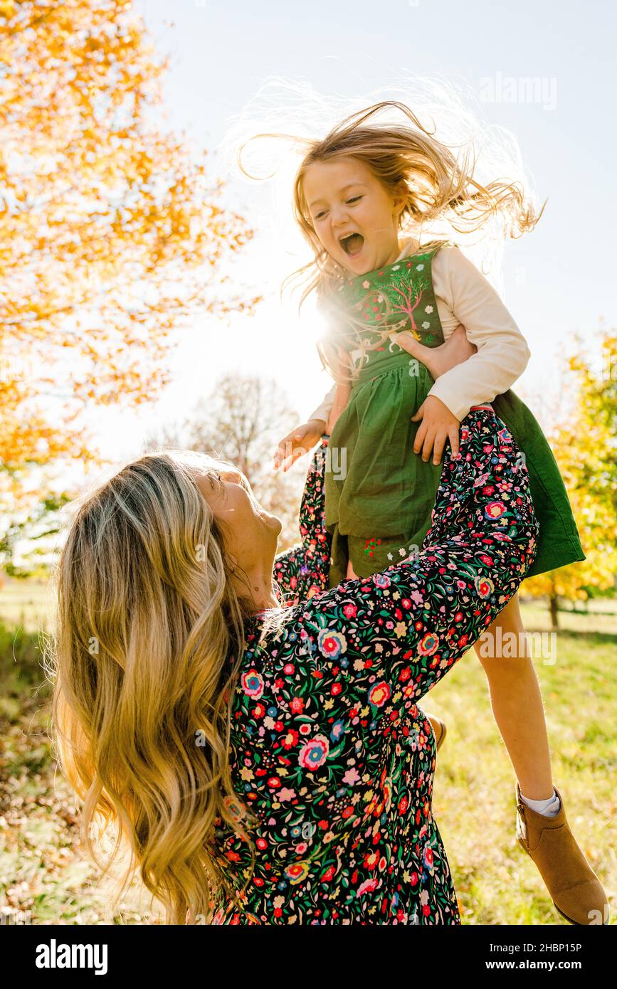 Closeup portrait of a mother throwing her daughter into the air Stock Photo