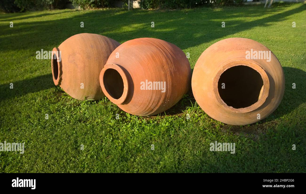 Large earthenware jars for garden decoration with rustic horizontal green grass Stock Photo