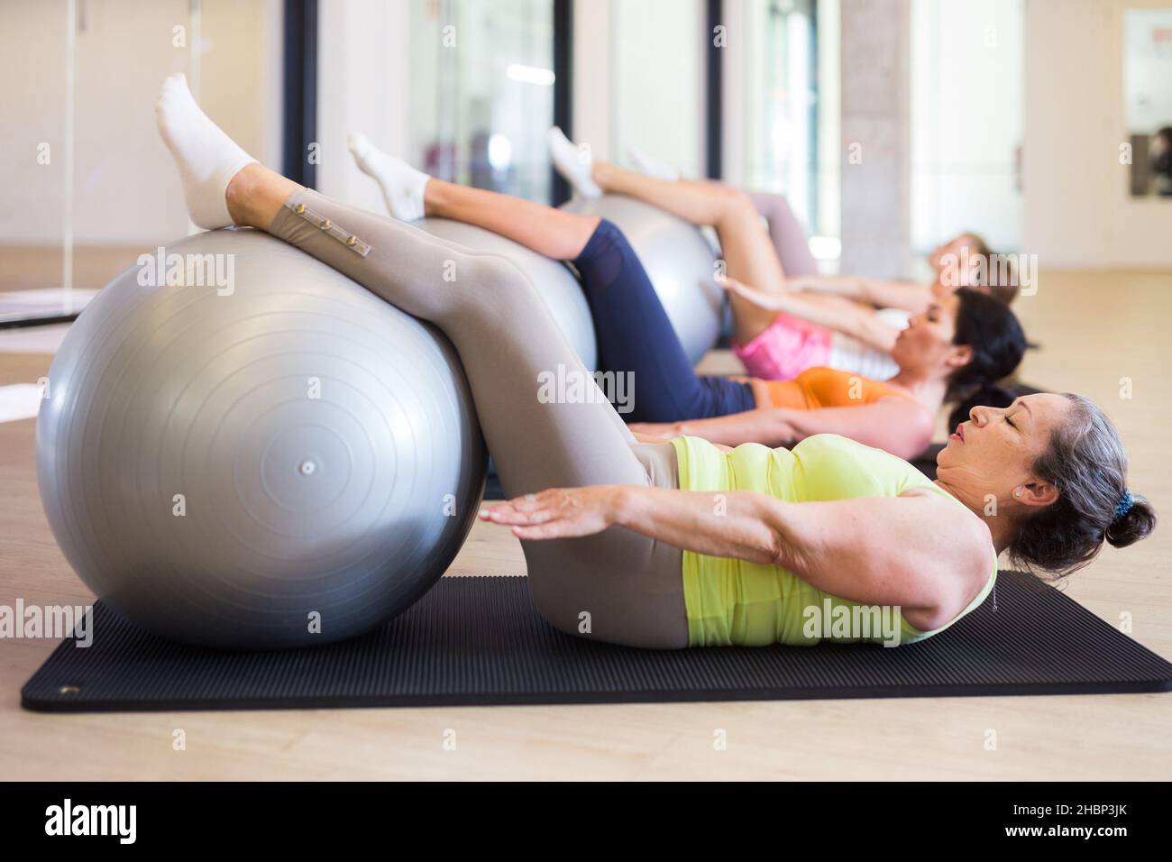 Four women doing crunches with swiss balls Stock Photo - Alamy