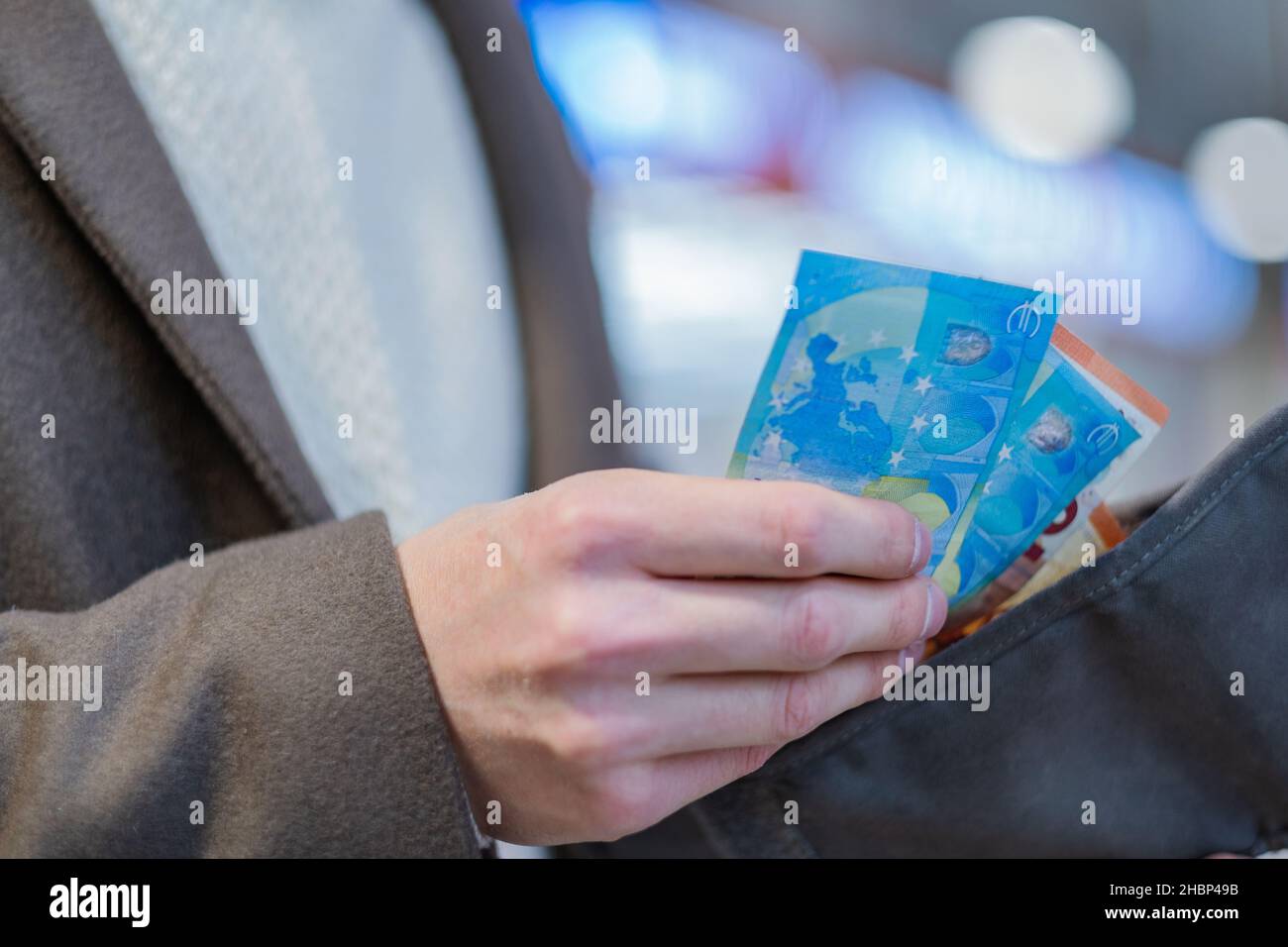 man in a coat takes euro bills out of his wallet, European currency close-up in his hands Stock Photo