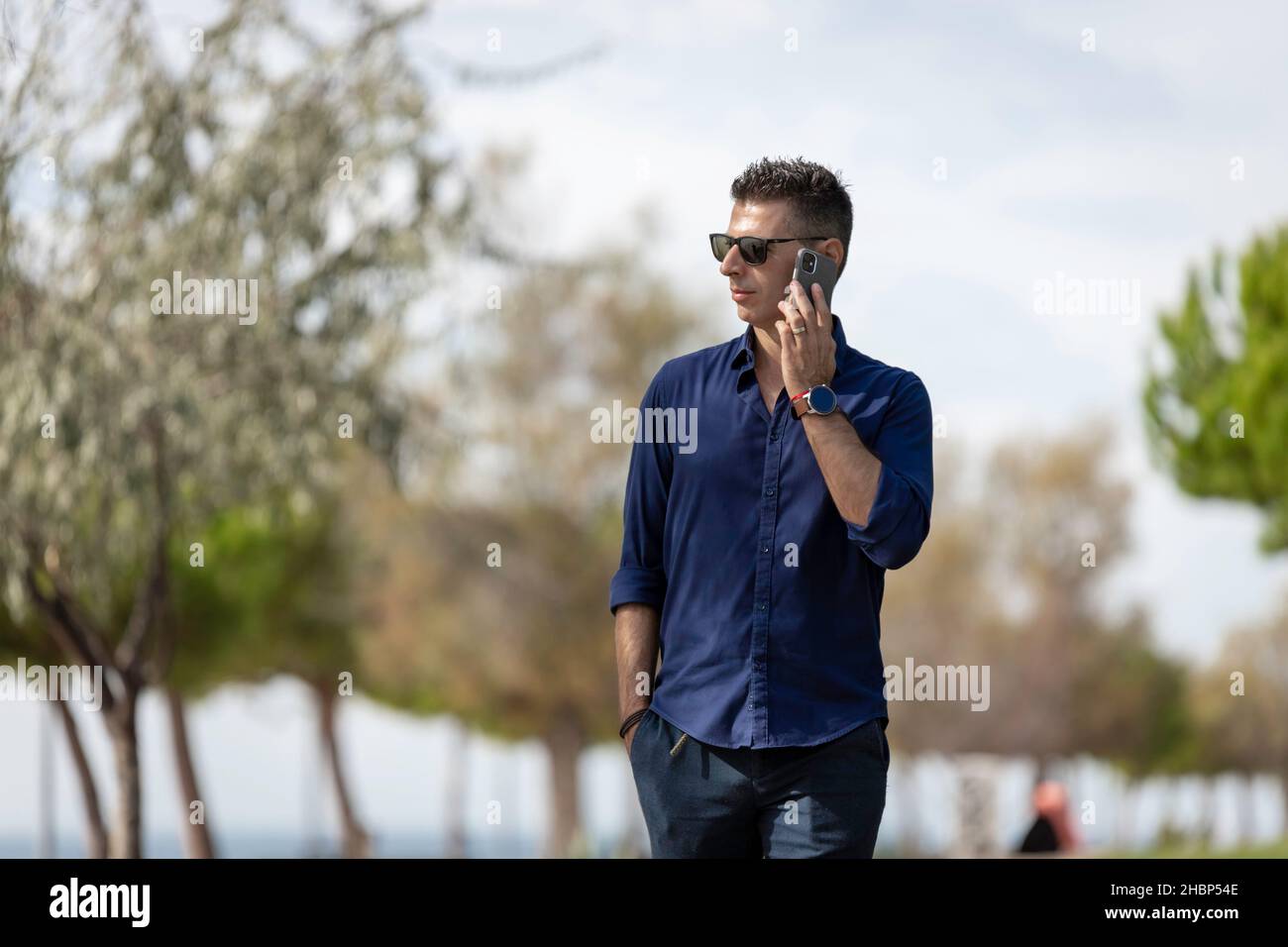 Beautiful and attractive young middle aged man walking alone and using ...