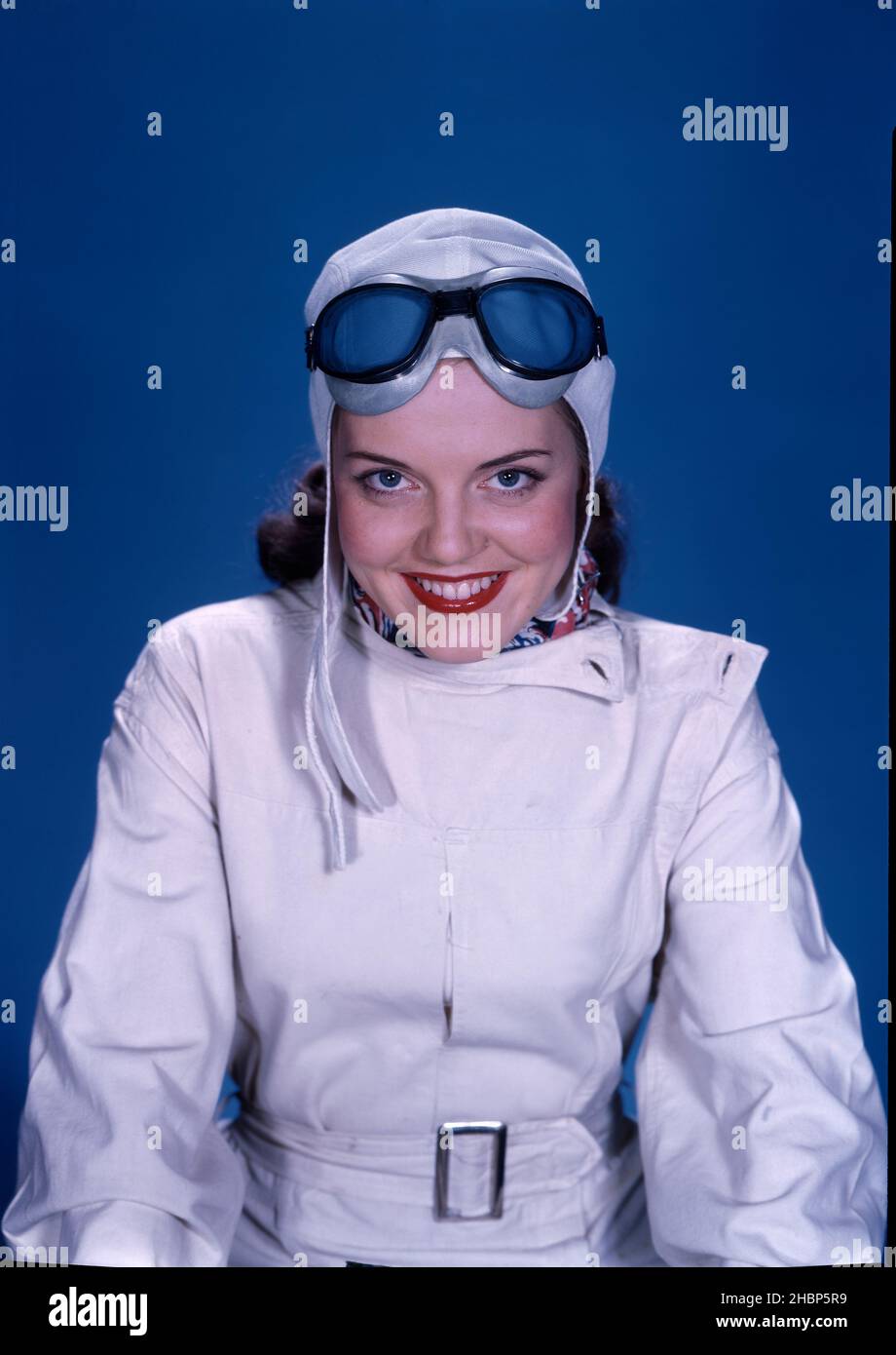 Teen girl posed in white aviation outfit with aviator hat and goggles Stock Photo