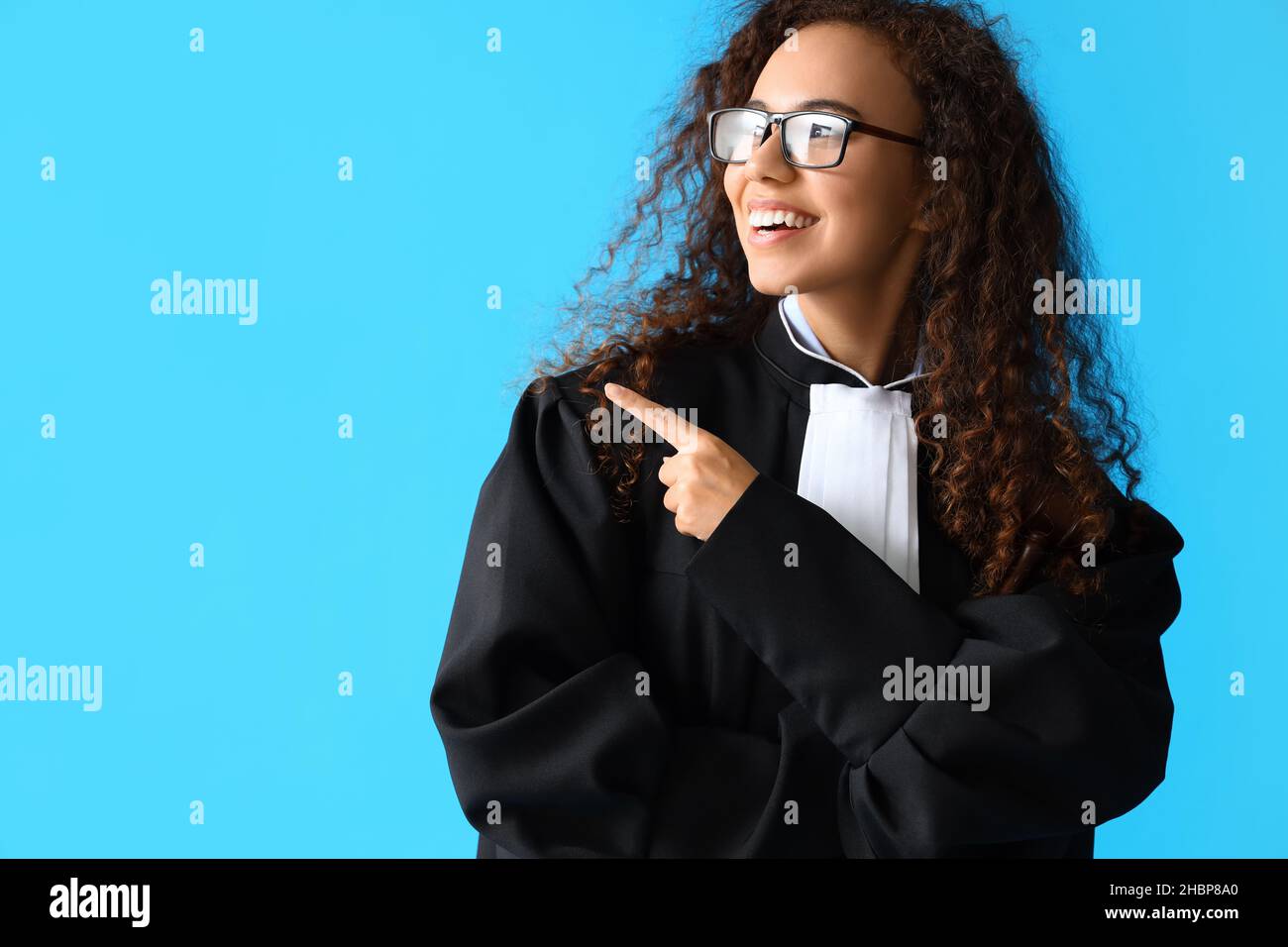 Portrait of female judge showing something on color background Stock ...