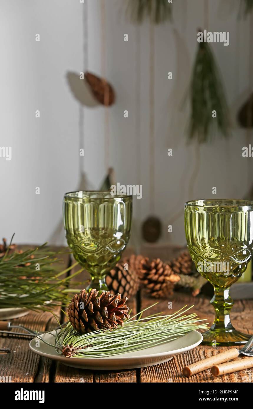 Beautiful table setting with pine cones and fir branches indoors Stock ...