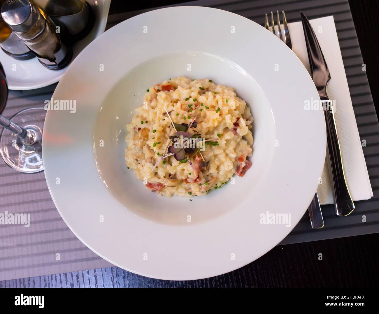 Creamy mushrooms and ham risotto garnished with greens Stock Photo - Alamy