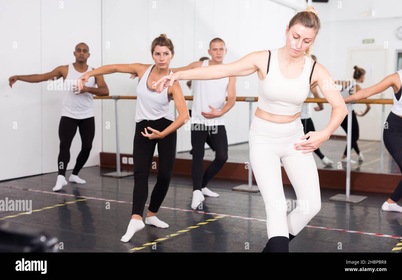Concentrated women and men rehearsing ballet dance Stock Photo