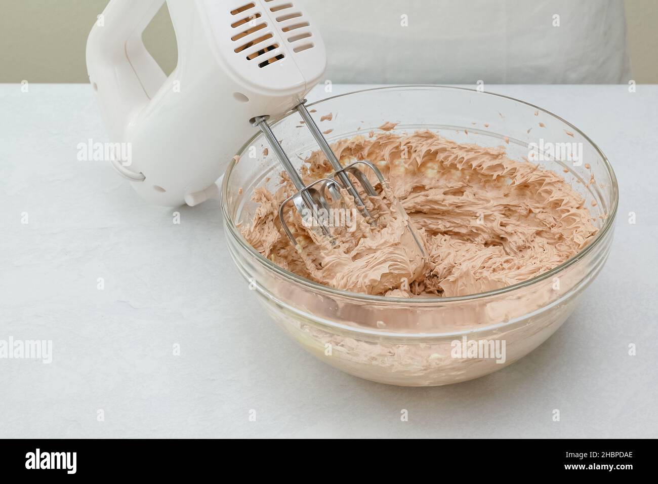 Electric whisk in mixing bowl with butter and flour