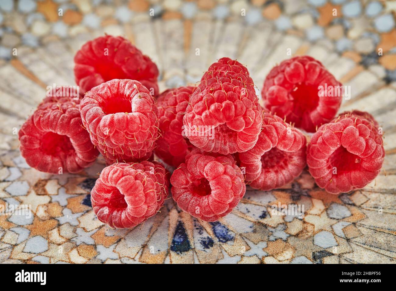 Fresh raspberries lying on plate for eating Stock Photo