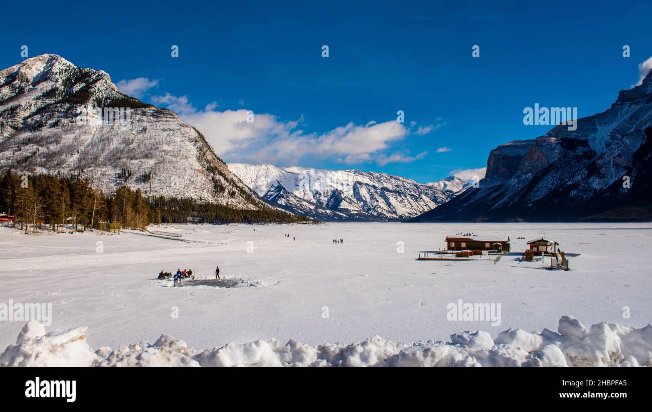 Beautiful winter views in Banff National Park Alberta Canada. Skating and fishing on frozen lake Minnewanka. Stock Photo