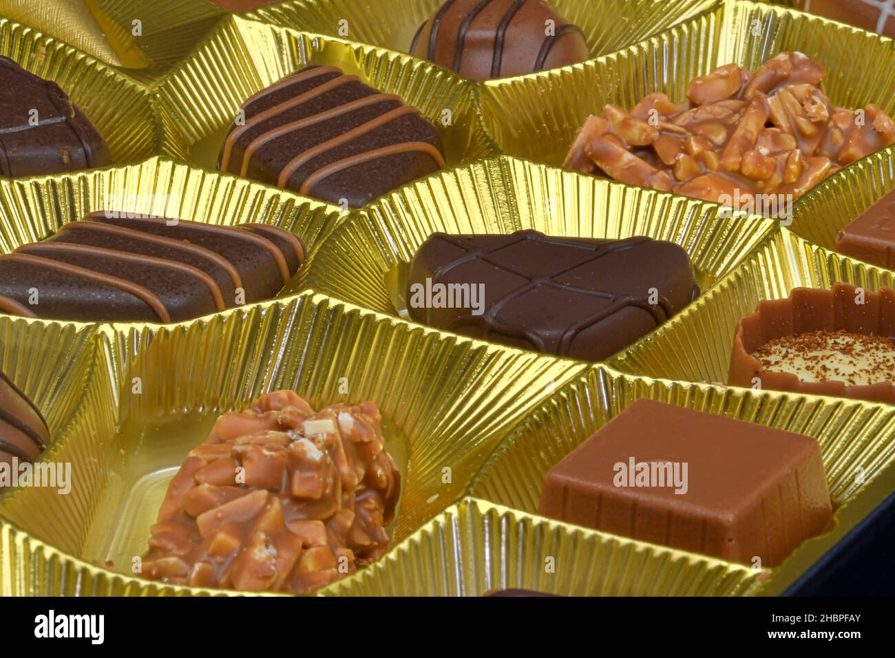 Different chocolate pralines in a golden box. Close up shot of