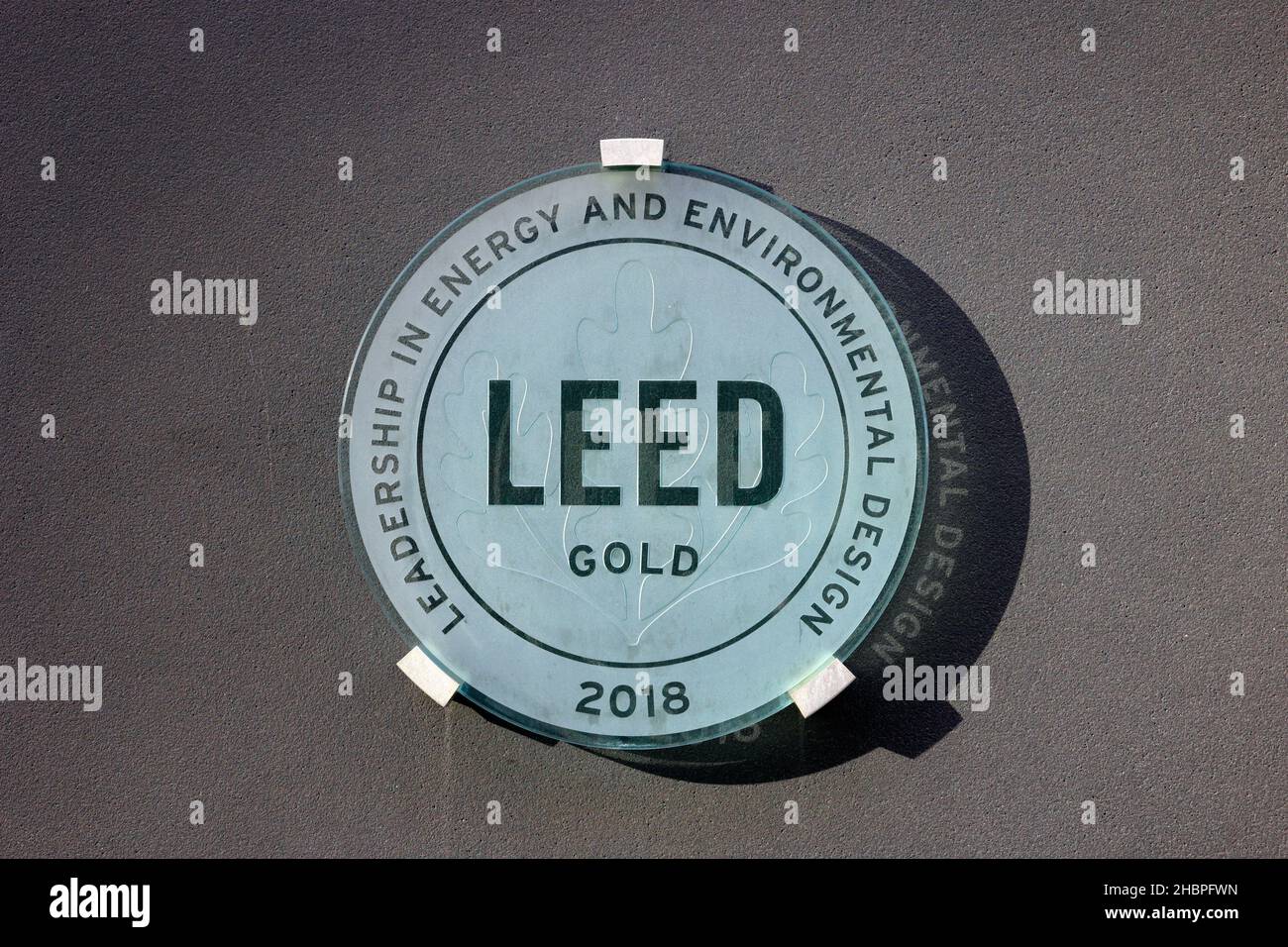 A US Green Building Council LEED Gold plaque indicating a building has achieved compliance with different aspects of sustainability and resiliency Stock Photo