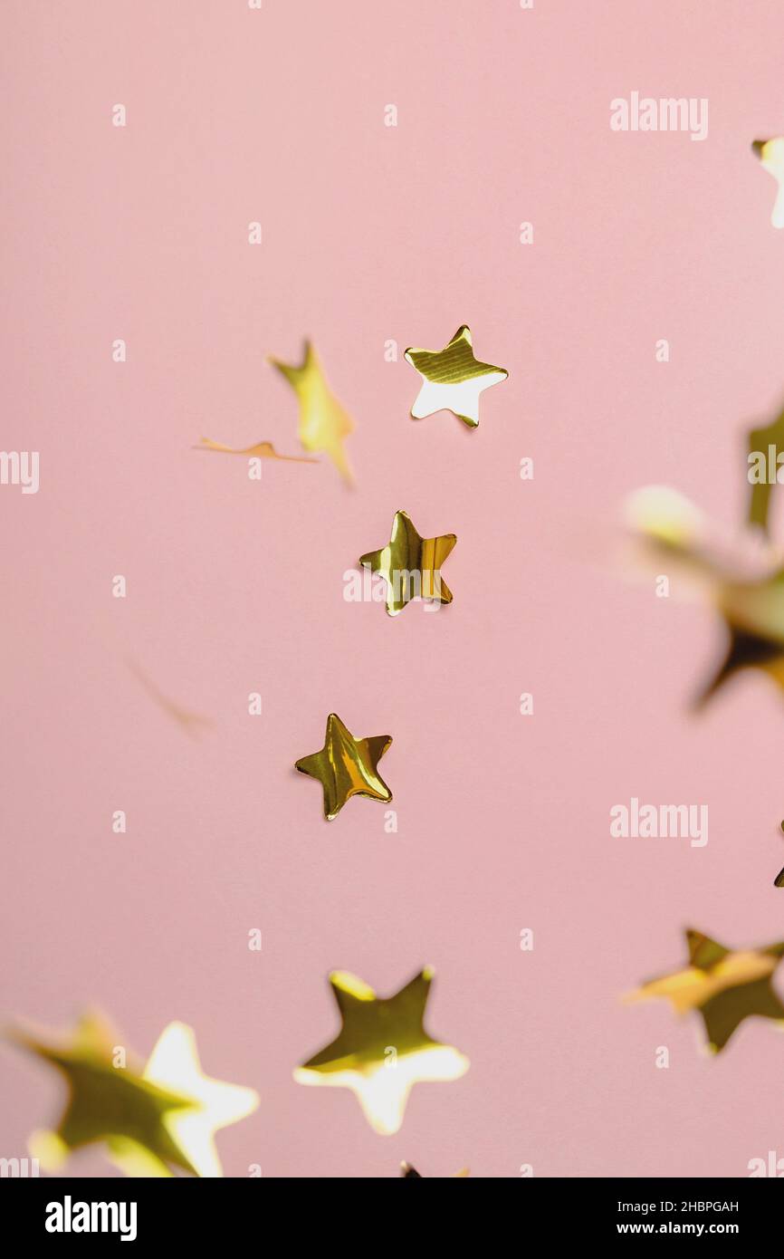 Background with flying gold confetti stars. Pink background. Wallpaper ...