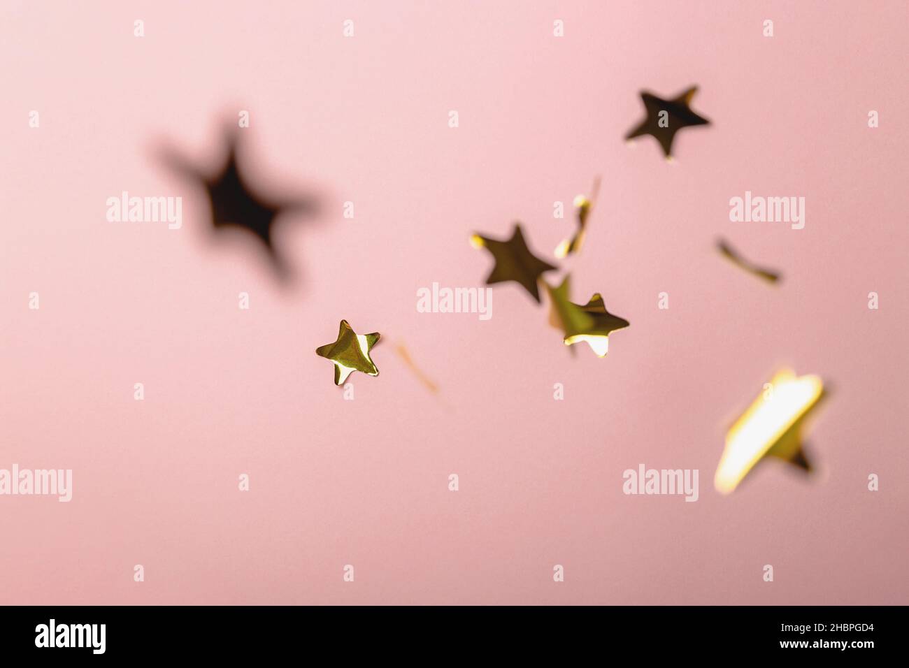 Background with flying gold confetti stars. Pink background. Wallpaper ...
