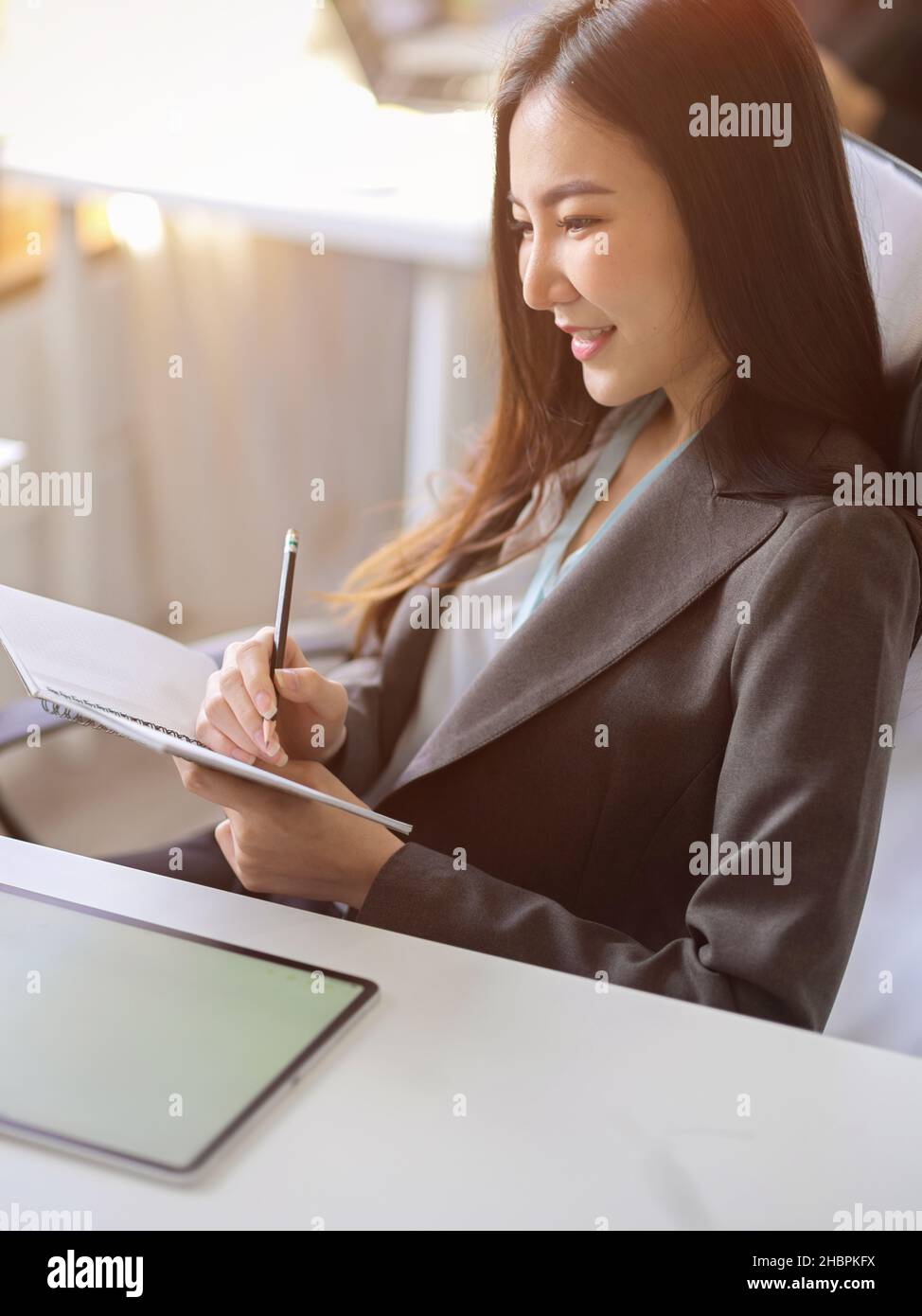 Portrait image of a beautiful asian young business woman taking notes ...