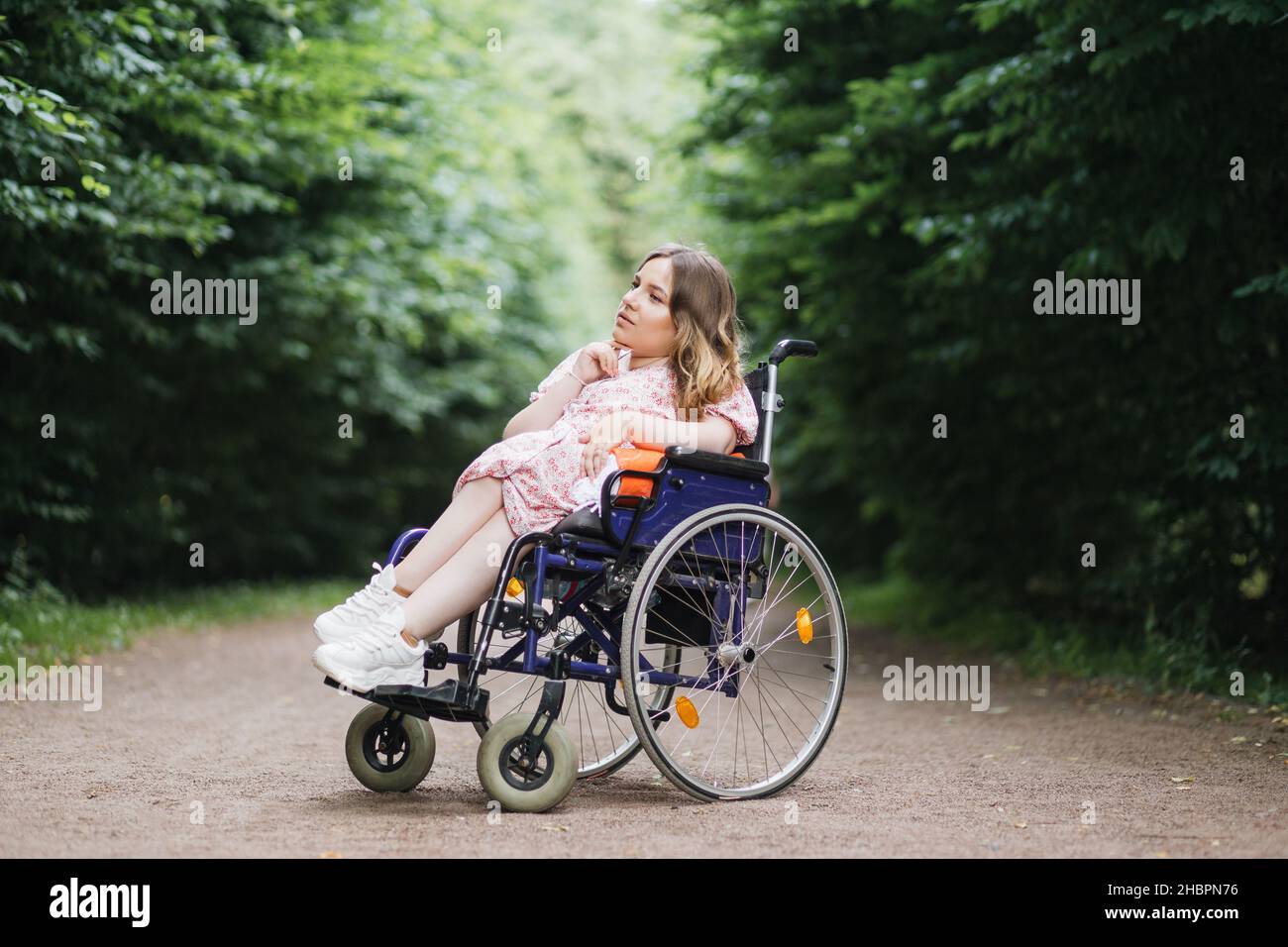 Female person with spinal muscular atrophy spending time outdoors alone  with her thoughts. Young woman who using wheelchair sitting among green  summer park and looking aside Stock Photo - Alamy