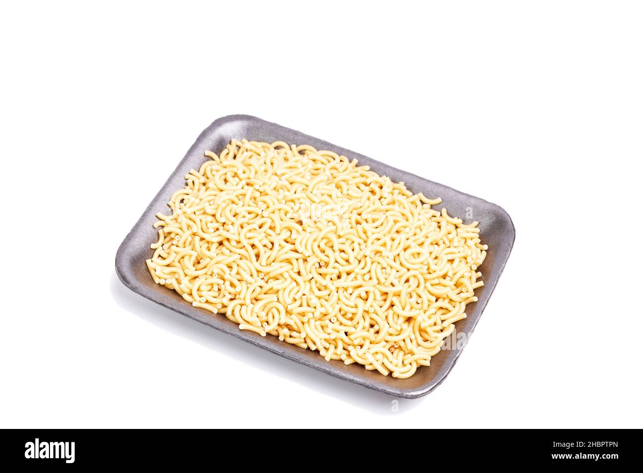 Black tray filled with fideua, pasta, on a white background. Healthy food sales concept Stock Photo