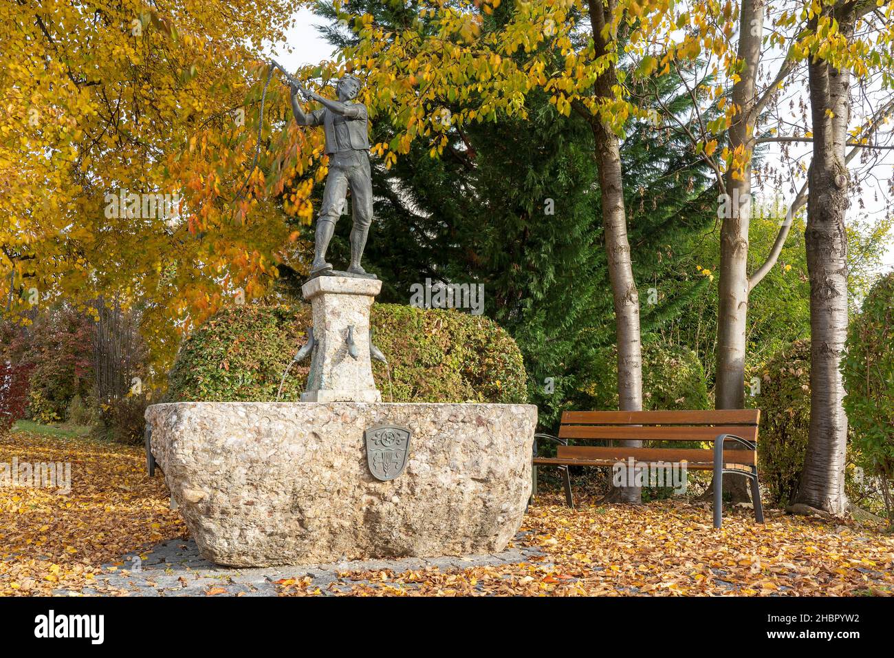 der herbstiche Schnalzerbrunnen in Saaldorf,  Berchtesgadener Land, Oberbayern Der Bildhauer H. Messner aus Munderfing in Österreich hat den Brunnen g Stock Photo