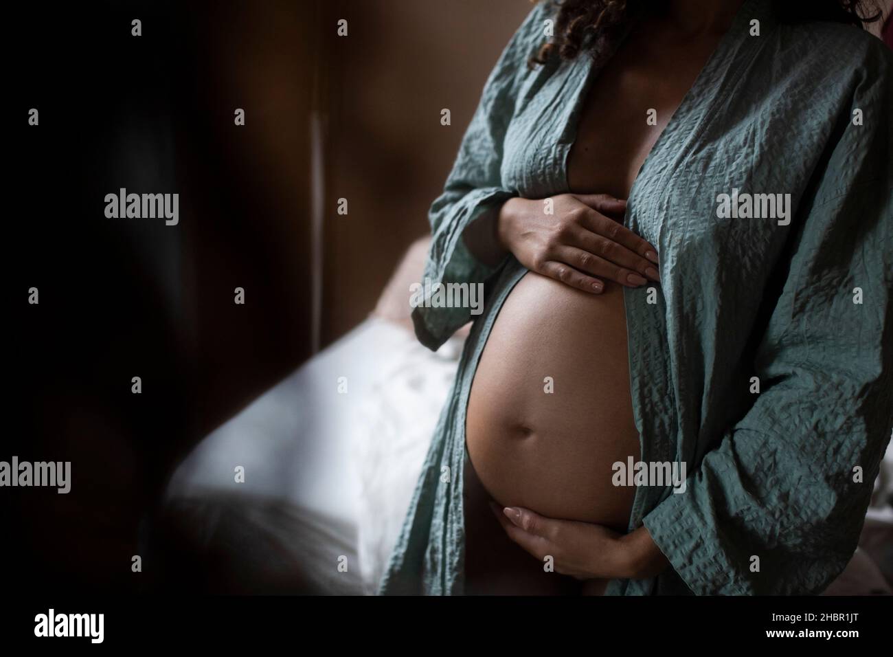 Midsection of pregnant woman touching belly at home Stock Photo