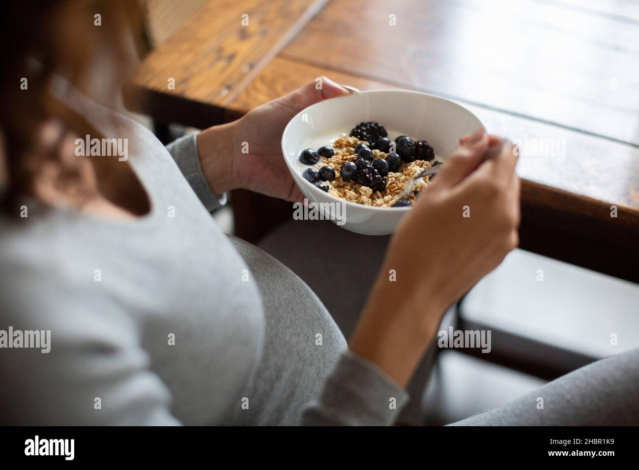 Midsection of woman having oats during breakfast at home Stock Photo