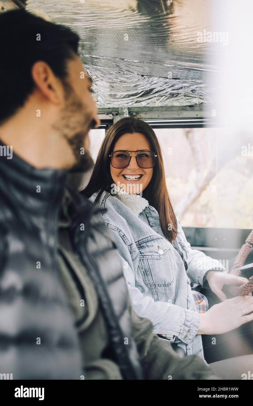Happy male and female friends sitting in sports utility vehicle Stock Photo