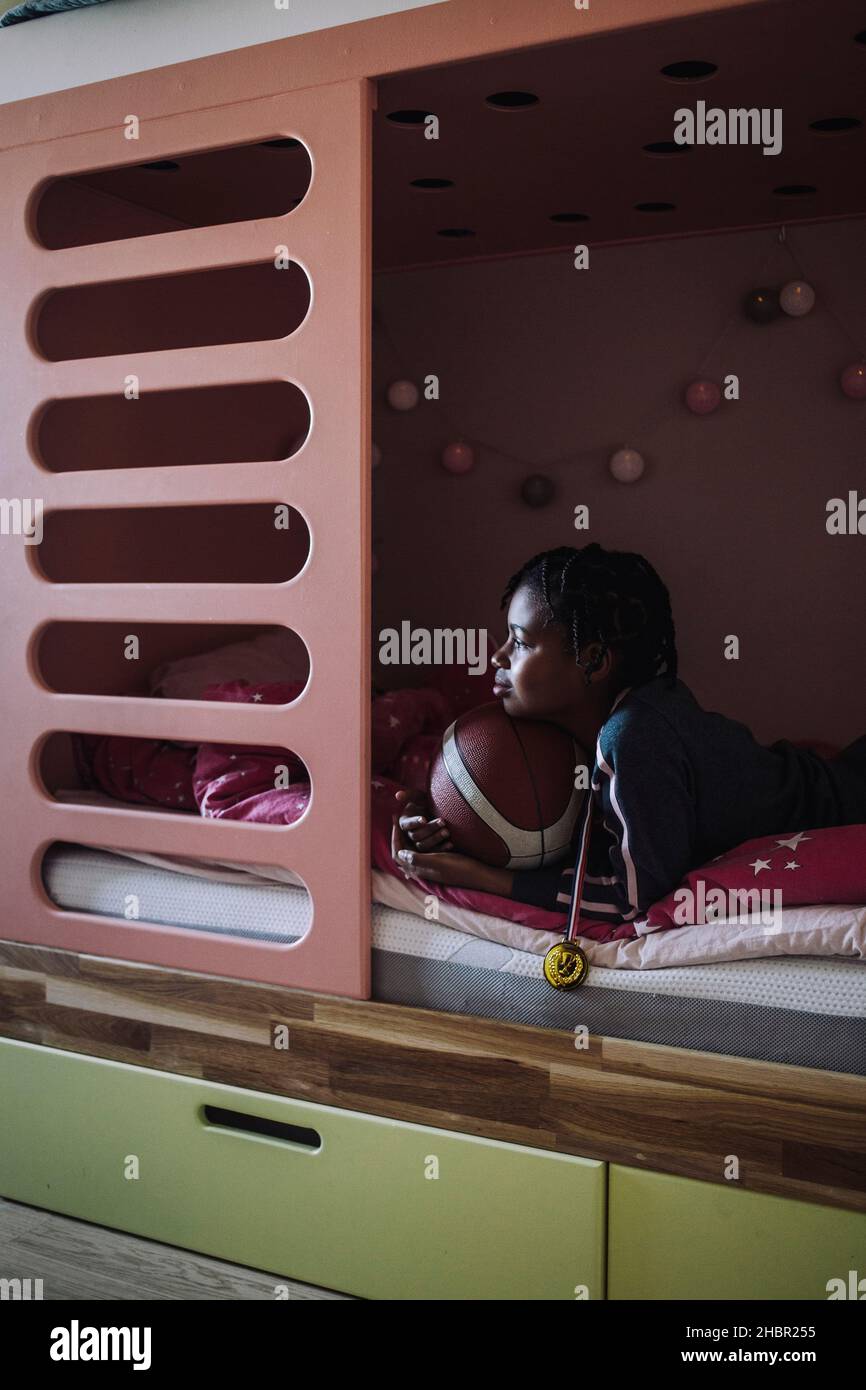 Girl lying down with basketball on bed in bedroom Stock Photo Alamy