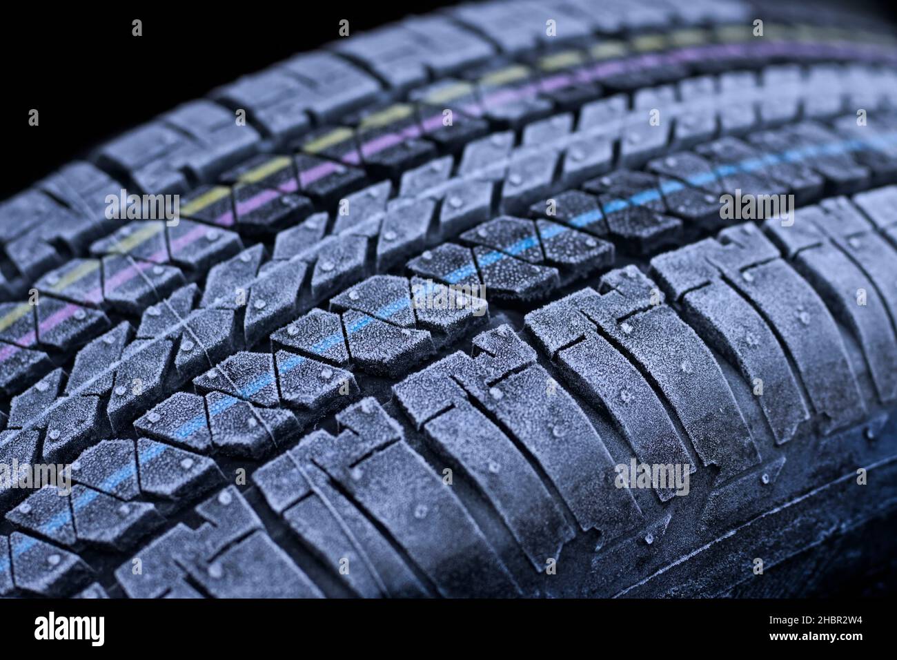 Frosted car tires close-up wheel profile structure on black background. Stock Photo