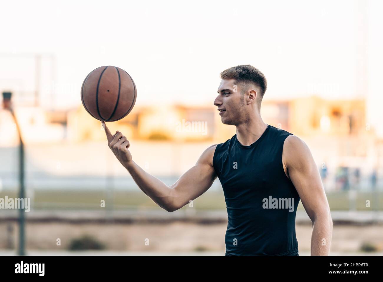 Basketball player juggling a ball on an outdoor court Stock Photo Alamy
