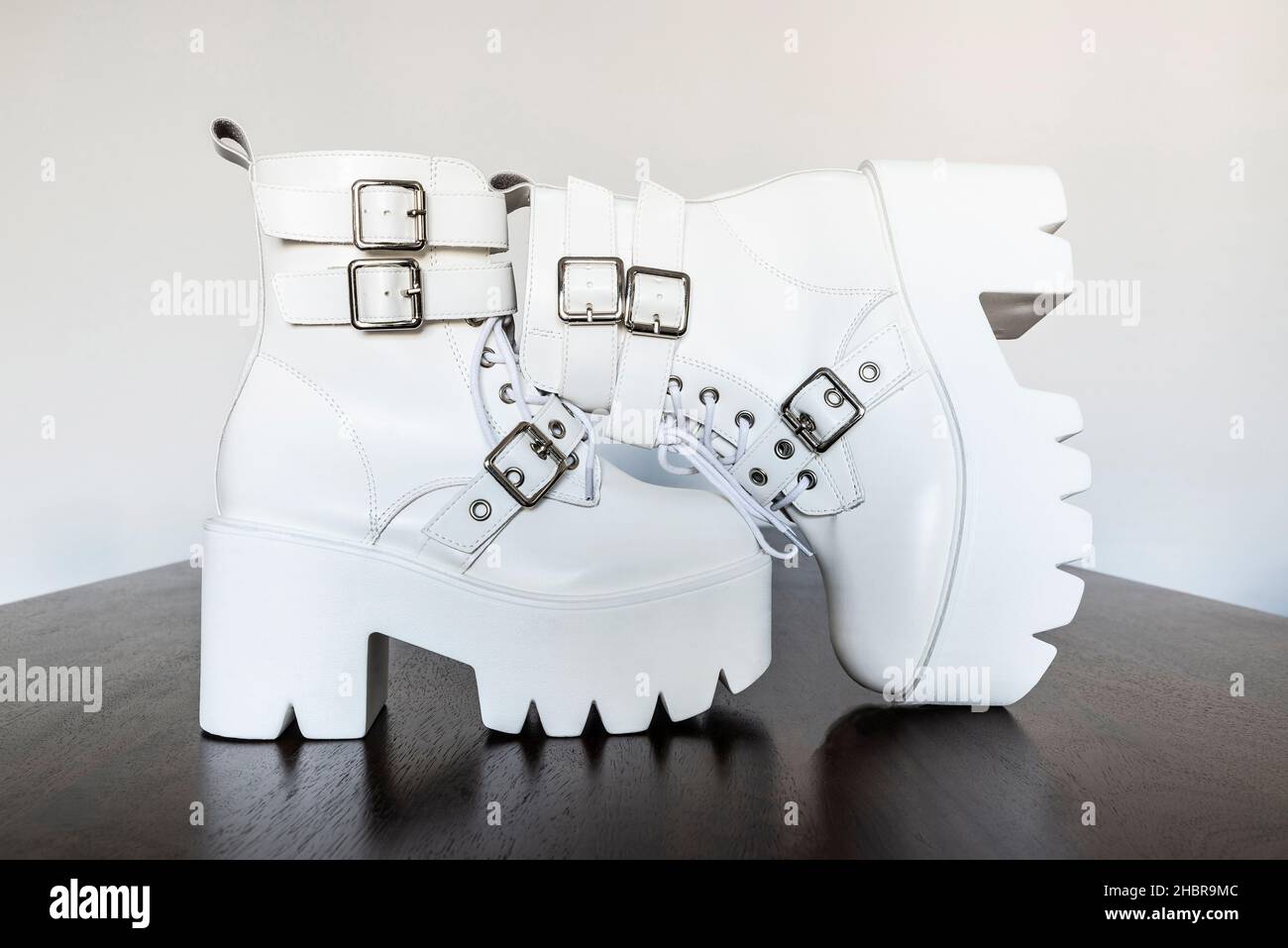 Modern white platform boots with buckles and laces with an plastic thick sole Stock Photo