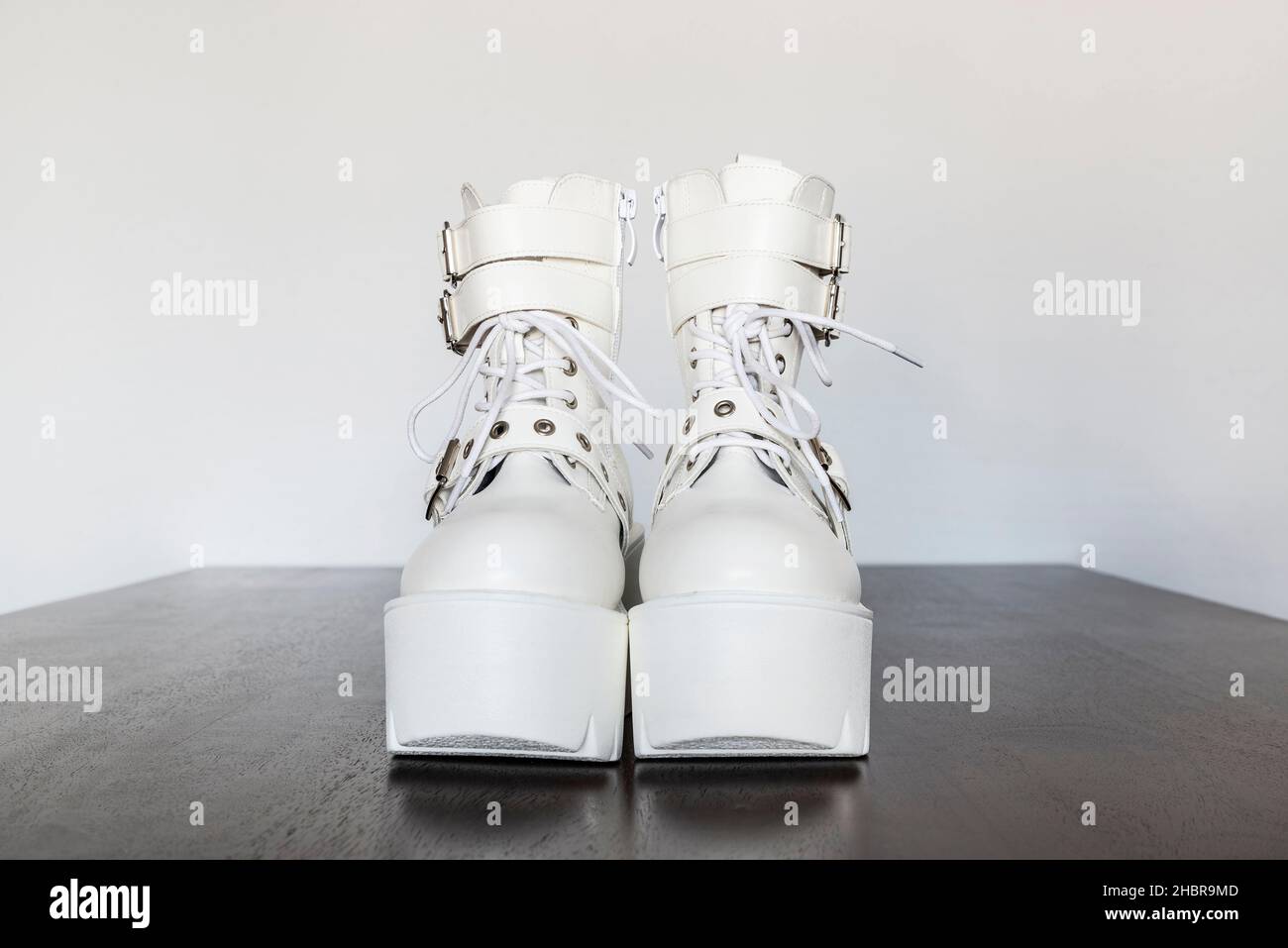 Modern white platform boots with buckles and laces with an plastic thick sole Stock Photo