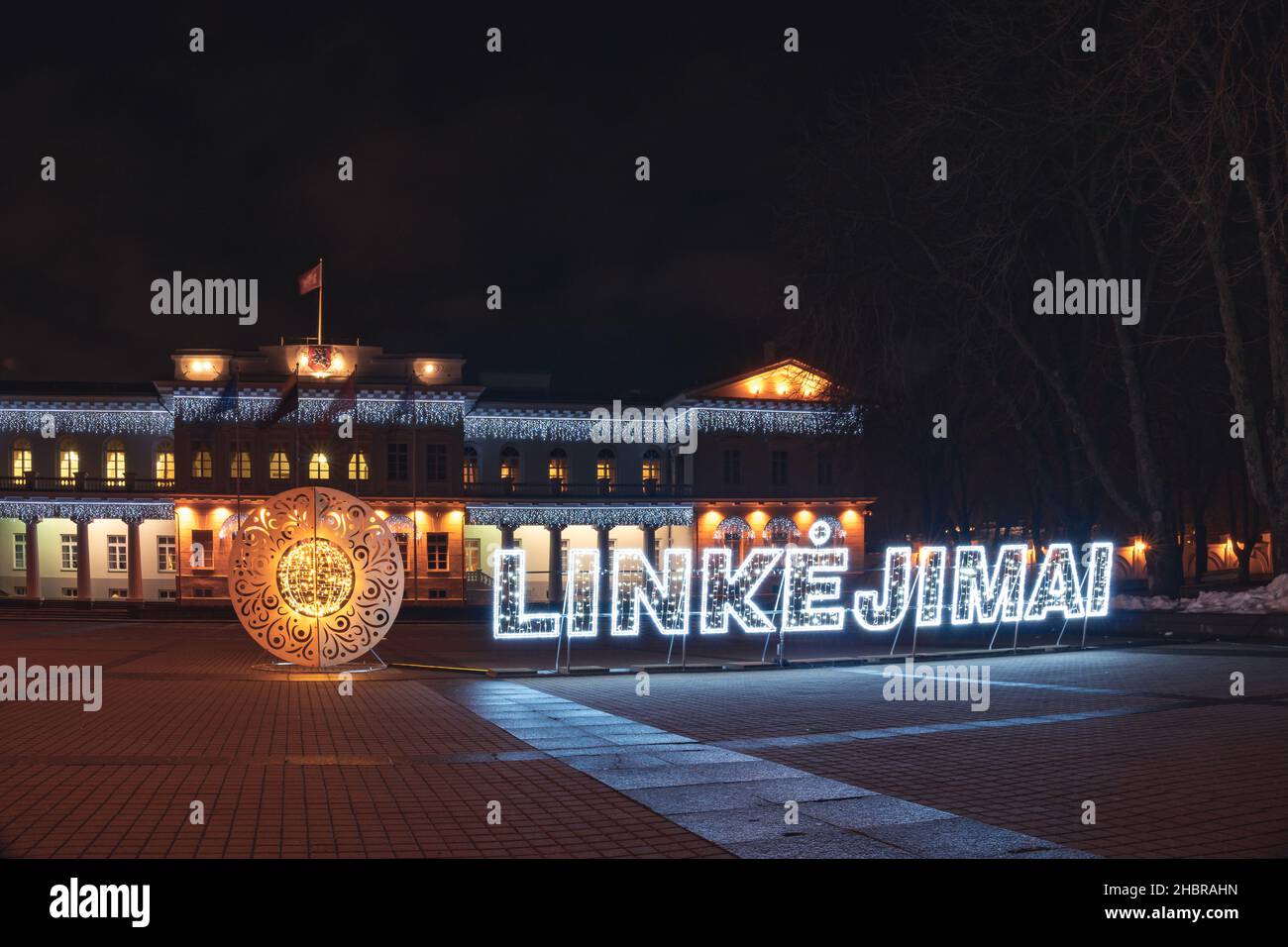 Vilnius, Lithuania - December 17th, 2021: illuminated word Greetings in Lithuanian - Linkejimai - near Presidential Palace Stock Photo