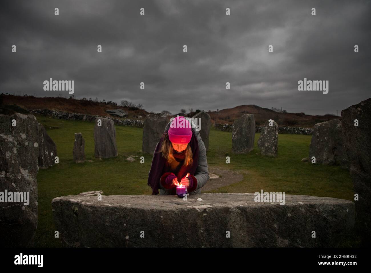 Drombeg, Glandore, Cork, Ireland. 21st December 2021.Shaman and healer Amy Russell from Rosscarbery lighting a candle on the Altar Stone while  waiting to observe the Sunrise during the Winter solstice at Drombeg Stone Circle outside Glandore, County Cork, Ireland. - Credit; David Creedon / Alamy Live News Stock Photo