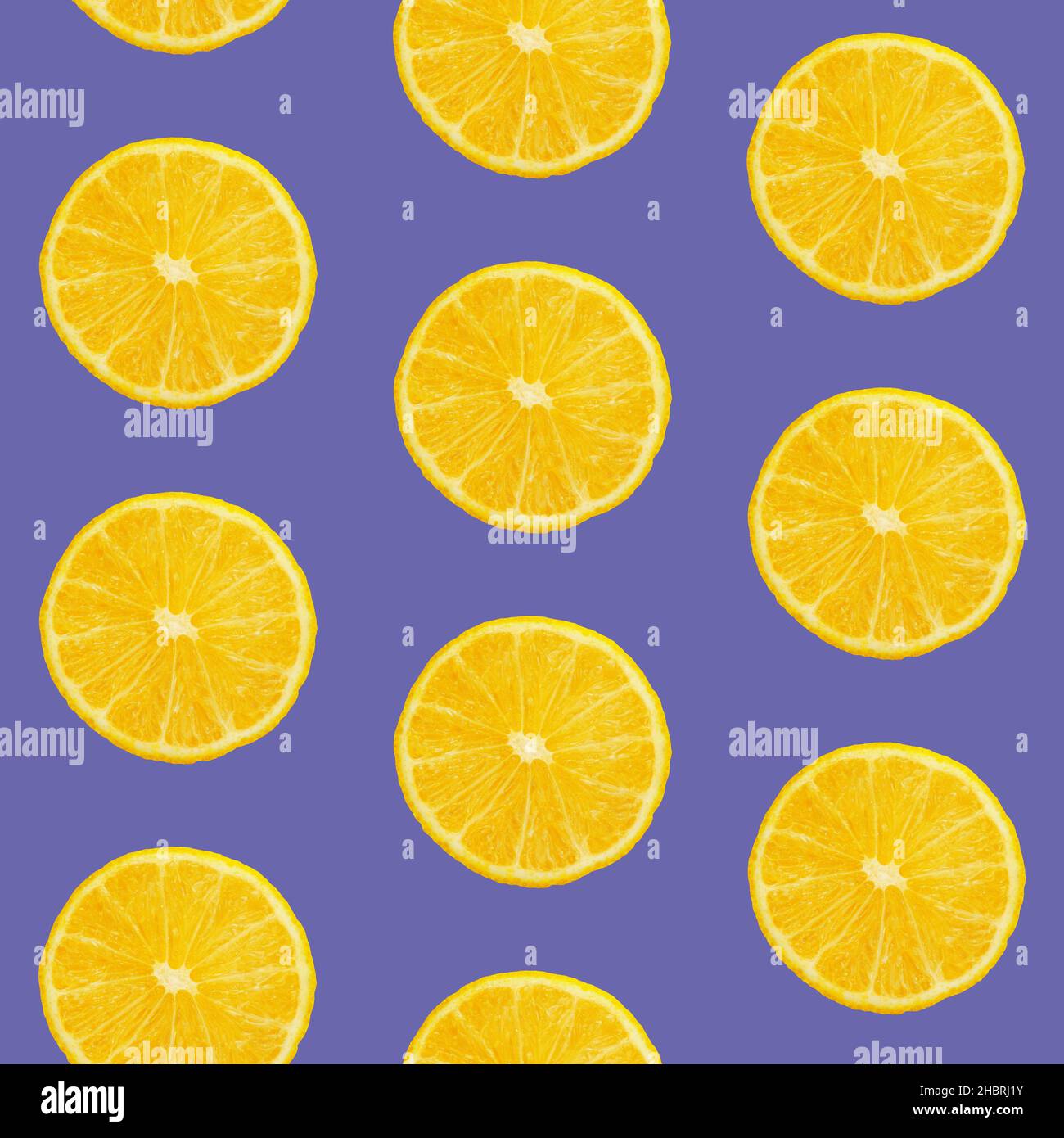 Seamless pattern of fresh ripe orange round cut wedges on lavender purple background, very peri, color of year 2022 Stock Photo
