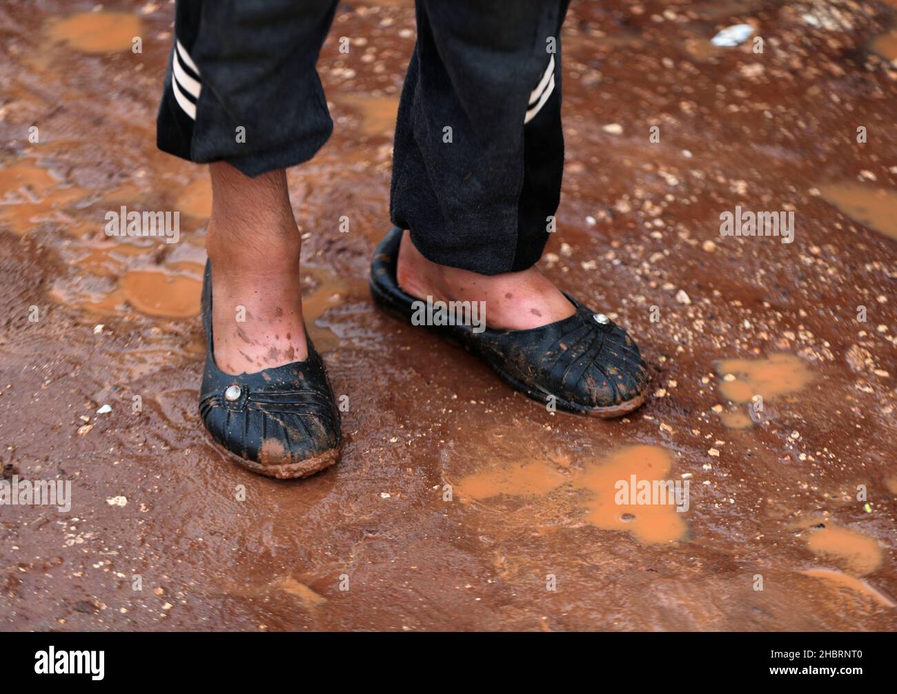 Internally displaced Syrian boy stands in the mud after heavy rain at Kafr Arouk camp in Idlib, Syria December 20, 2021. Picture taken December 20, 2021. REUTERS/Khalil Ashawi Stock Photo