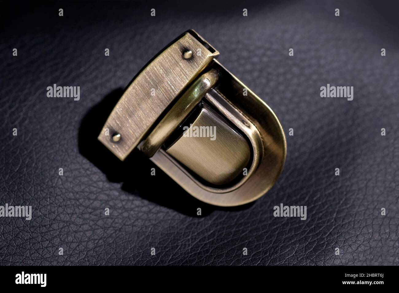 https://c8.alamy.com/comp/2HBRT6J/gold-shiny-lock-on-the-bag-close-up-metal-lock-on-a-black-background-fittings-for-accessories-metal-parts-for-the-sewing-industry-high-quality-twi-2HBRT6J.jpg