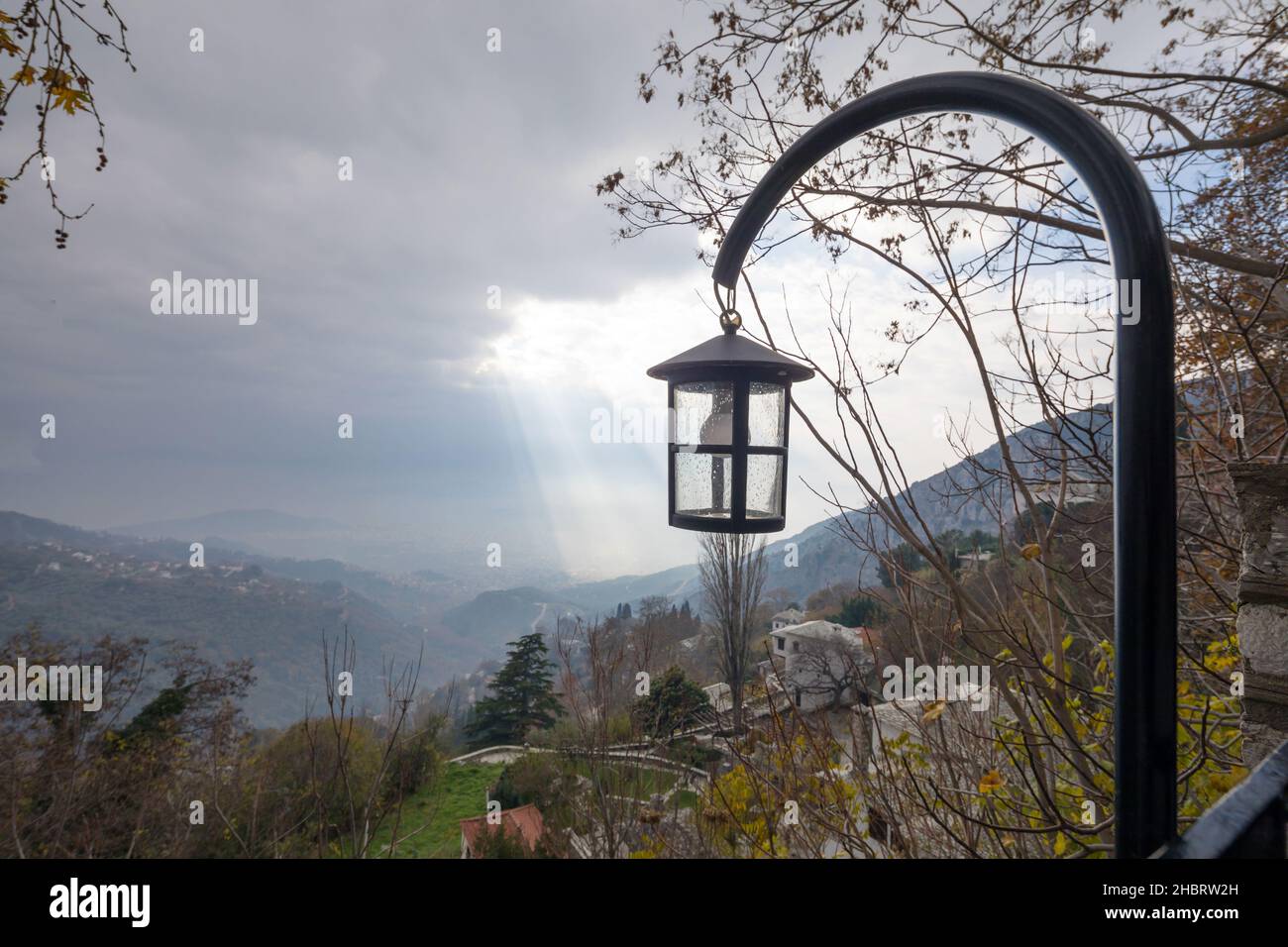 Close up of a lantern with sun rays and clouds in the background Stock Photo