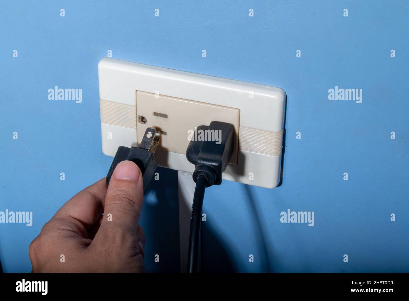 Man's hand plugging in a black wire. Latin, Colombian electrical outlet Stock Photo Alamy