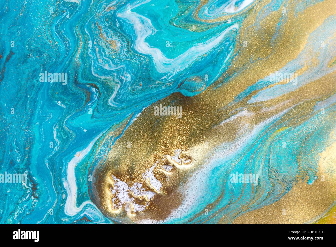 Streams of liquid blue, white and gold ink curls. Waves of fluid turquoise and golden fluid paint. Stock Photo