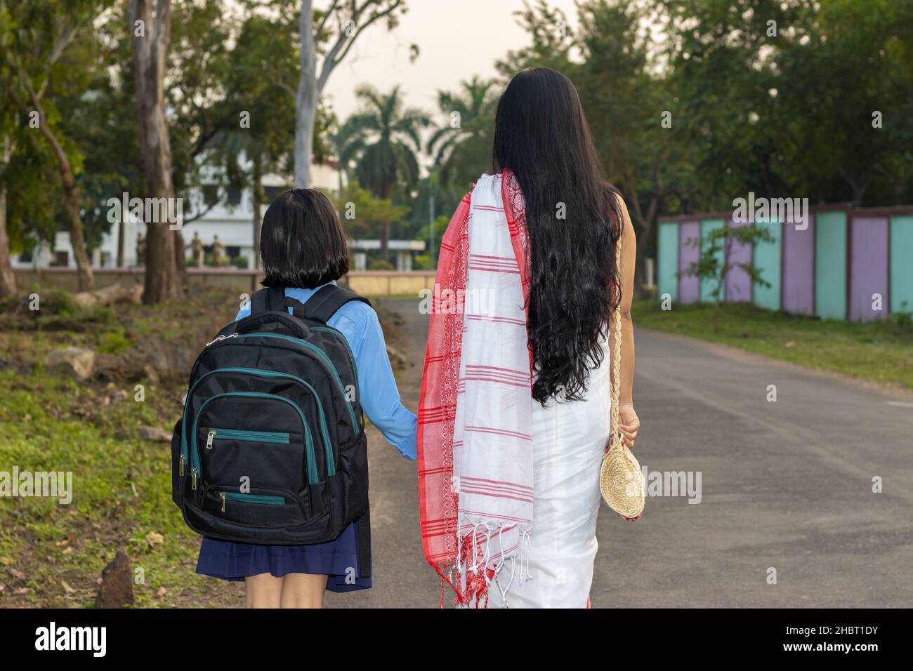 An Indian school girl child going to school with her mother Stock Photo