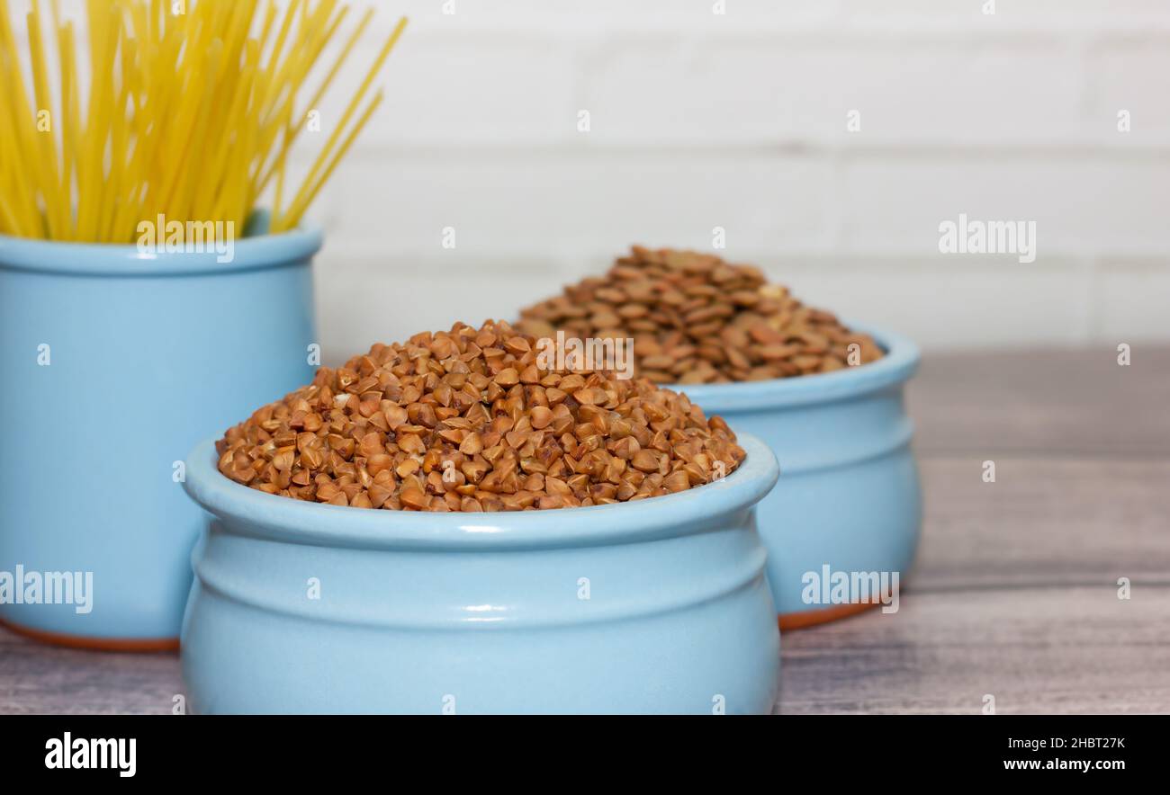 cereals and pasta in faience, blue dishes on a wooden table. cooking concept. perfect backdrop for cafe, dining room. soft focus. Stock Photo