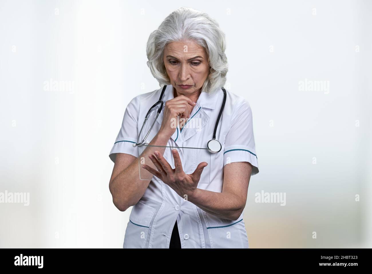 Thoughtful senior female doctor hi-res stock photography and images - Alamy