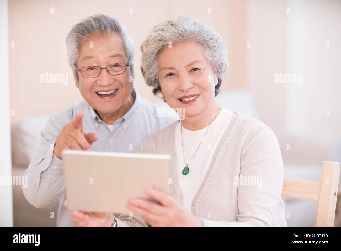 Elderly couple using a tablet computer at home Stock Photo